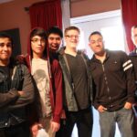 a group photo of the band within patterns along with john garcia and hector gomez in the tracking room at let down studio during the day time.